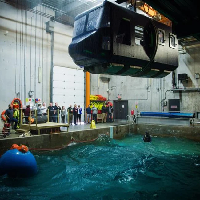 cabin descending into the water to showcase safety and sea survival techniques in confined spaces